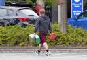 A man carrying containers at a Tesco Petrol Station in Bracknell, Berkshire. Picture date: Saturday September 25, 2021. PA Photo