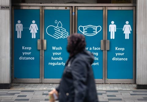 A person passes social distancing signs as they make their way along the High street in Slough, Berkshire, in the final week of a four week national lockdown to curb the spread of coronavirus (PA)