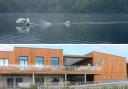 A swan lands on a lake at Dinton Pastures (photographed by Sharon Bust), where a £2.4m activity centre, pictured above, has opened to members of the public