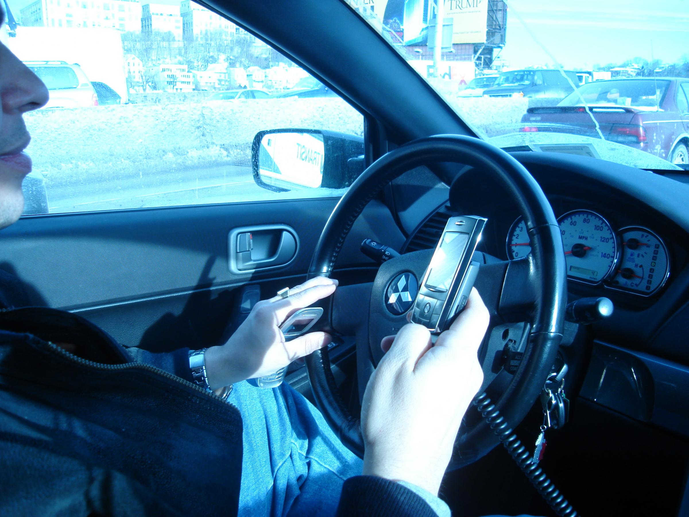Stock images of drivers using mobile phones. Images via DPP Law on Flickr and Wikimedia Commons