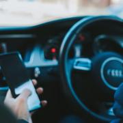 Stock image of someone using phone in the car